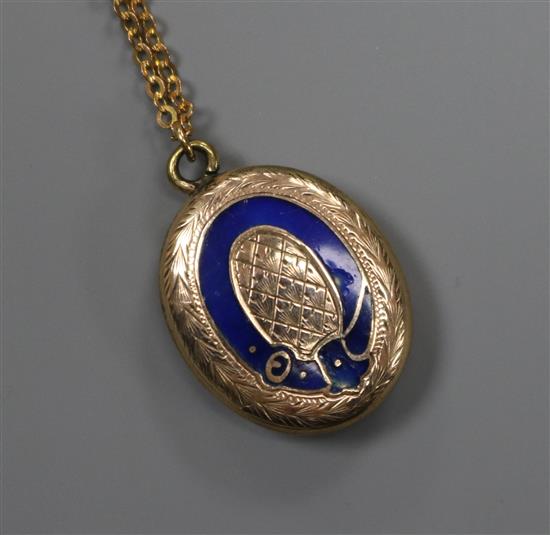 An early 20th century yellow metal and enamel oval locket with glazed back, on a later 9ct gold chain, locket 20mm.